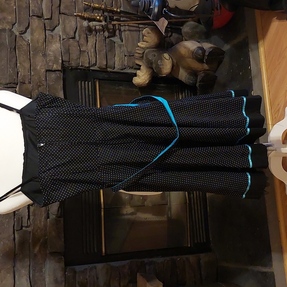 Black dress with white polka dots and med blue tie. Has netting underneath.